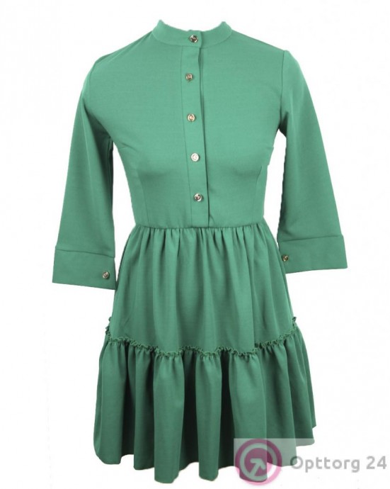 Женское платье зеленого цвета с золотистыми пуговицами.