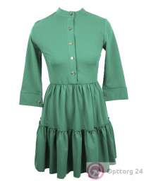 Женское платье зеленого цвета с золотистыми пуговицами.